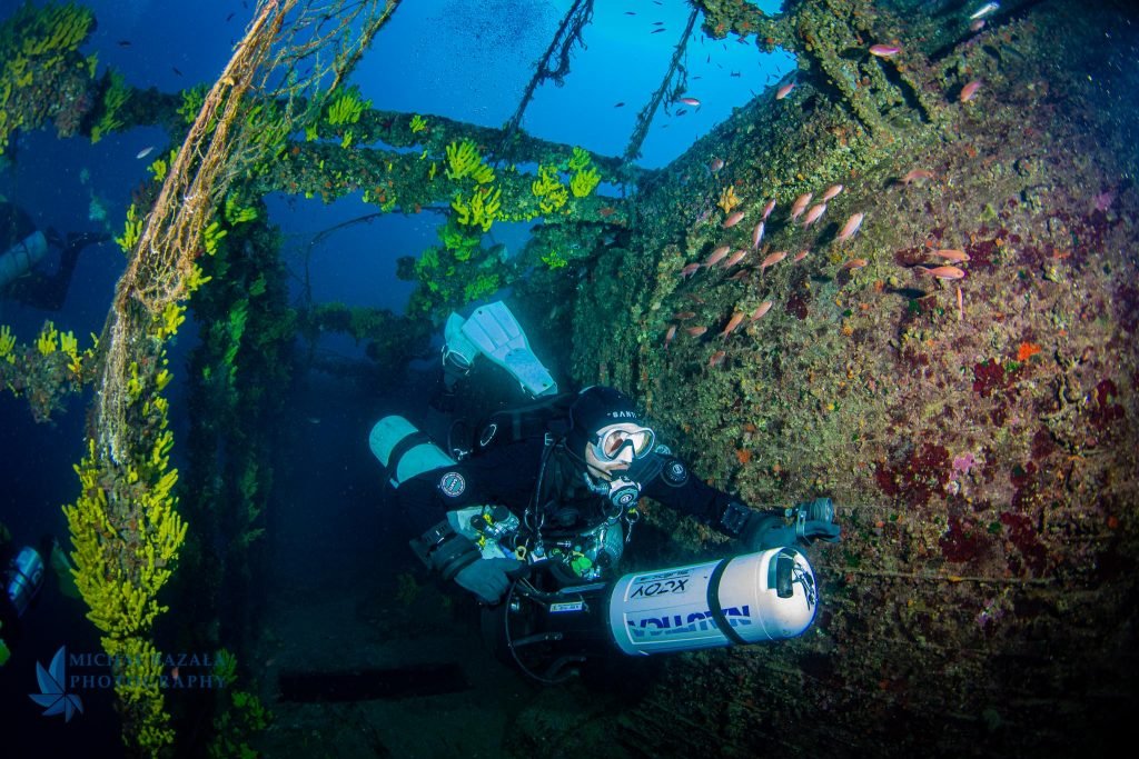 nurek techniczny eksploruje wrak statku przy użyciu podwodnego skutera DPV